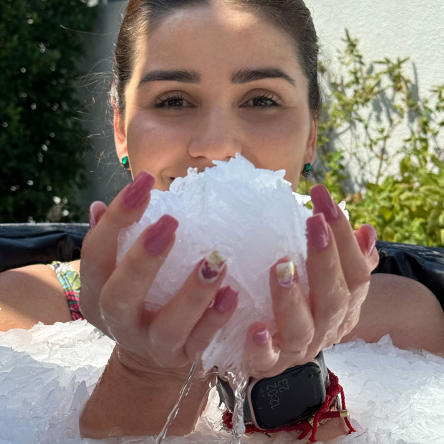 A woman enjoys a serene swim in an outdoor pool during a snowy winter day.